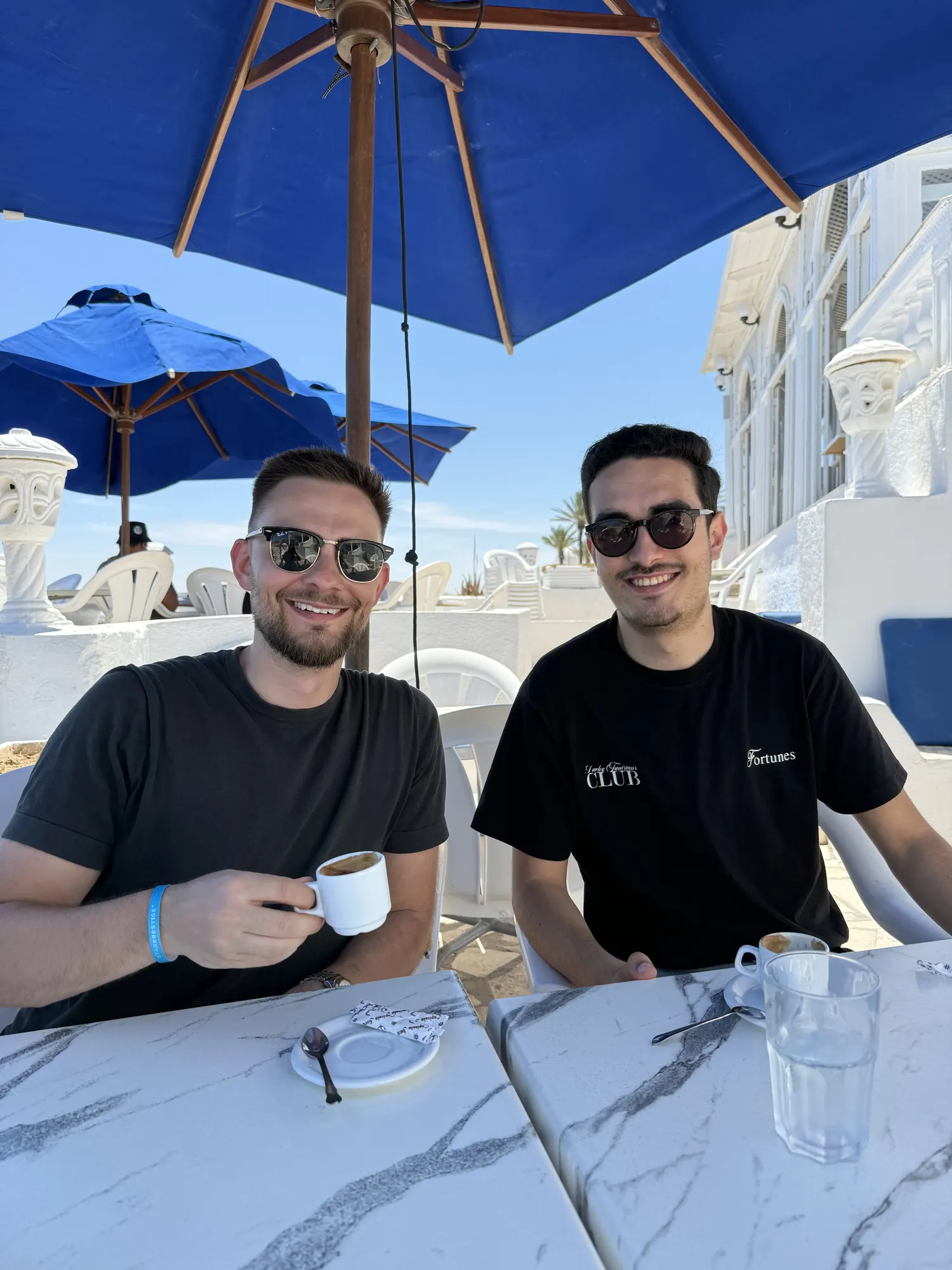 Vojtech and Yassine having coffee under a parasol